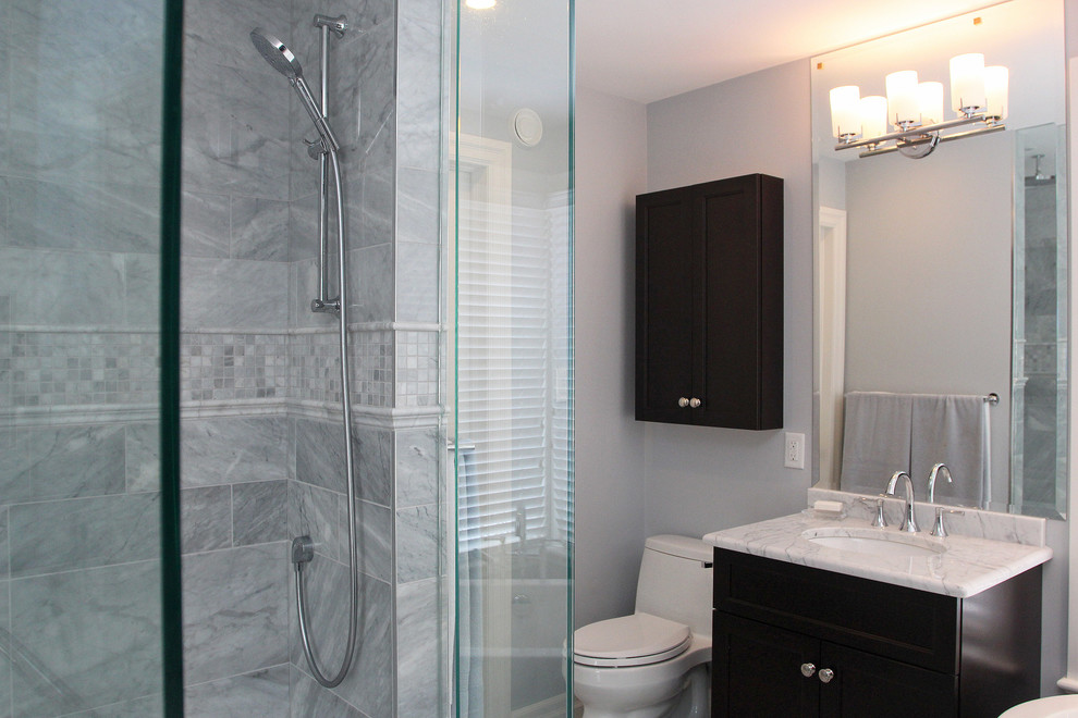Contemporary bathroom in Other with recessed-panel cabinets, dark wood cabinets, an alcove shower, a one-piece toilet, gray tile, ceramic tile, grey walls, an undermount sink, granite benchtops and a hinged shower door.