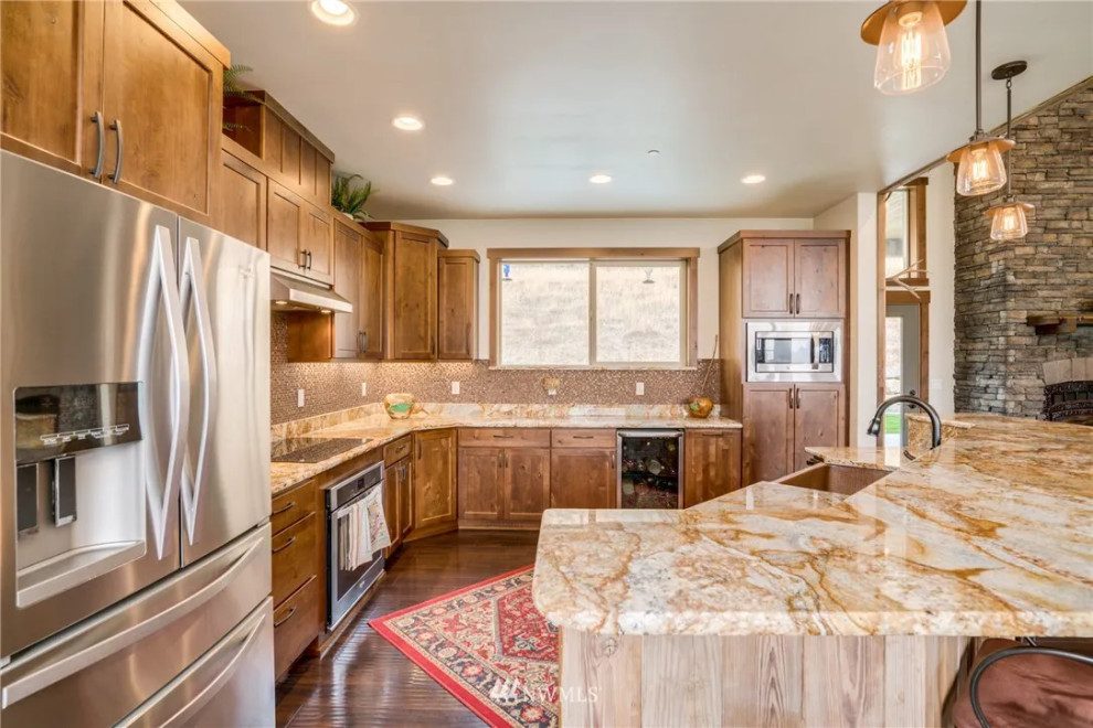 Inspiration for a mid-sized rustic l-shaped laminate floor, brown floor and tray ceiling open concept kitchen remodel with a single-bowl sink, shaker cabinets, medium tone wood cabinets, granite countertops, multicolored backsplash, glass tile backsplash, stainless steel appliances, an island and multicolored countertops