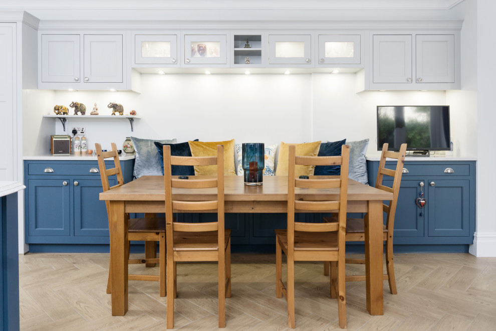 Offene, Einzeilige, Große Klassische Küche mit Schrankfronten im Shaker-Stil, blauen Schränken, Quarzwerkstein-Arbeitsplatte, hellem Holzboden, Kücheninsel, braunem Boden und weißer Arbeitsplatte in Cardiff