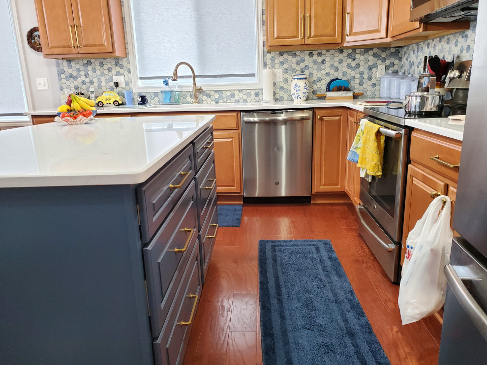 This is an example of an eat-in kitchen in Detroit with medium wood cabinets, quartz benchtops, blue splashback, ceramic splashback, stainless steel appliances, with island and white benchtop.