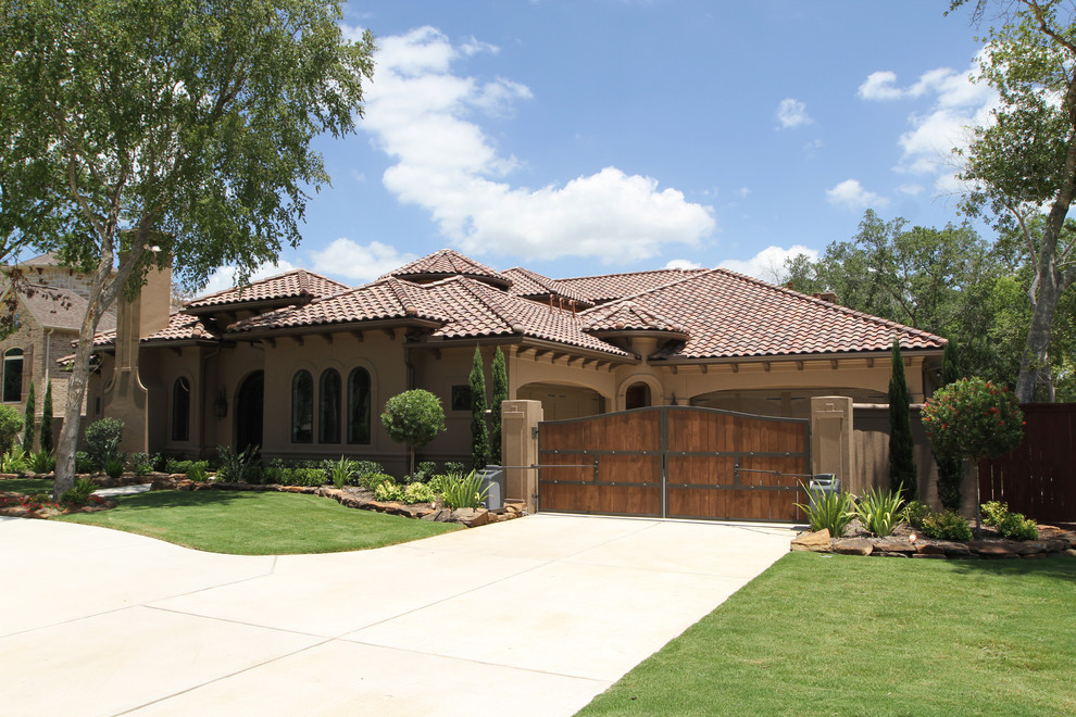 This is an example of a large mediterranean one-storey stucco brown exterior in Houston.