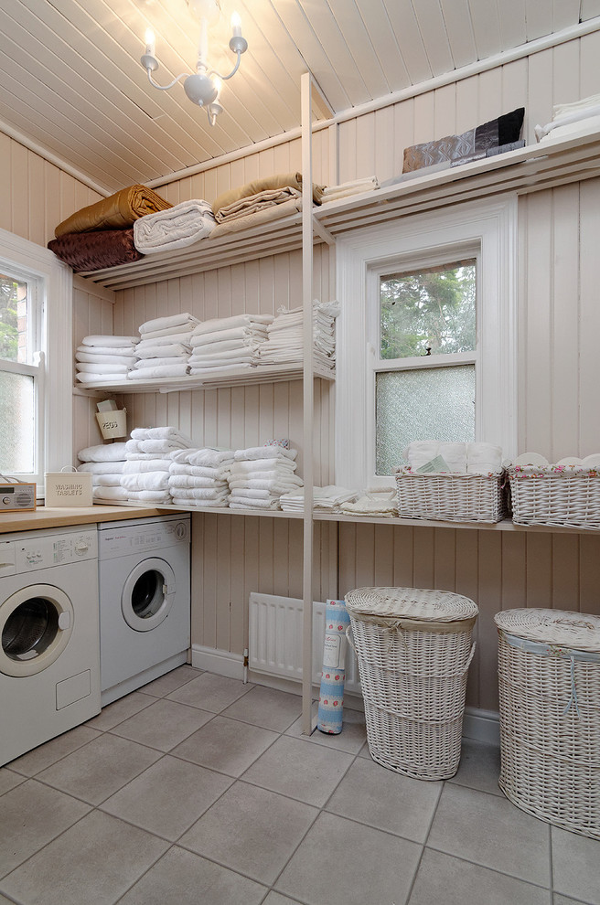 Photo of a traditional dedicated laundry room in Belfast with open cabinets, beige walls, a side-by-side washer and dryer and grey floor.