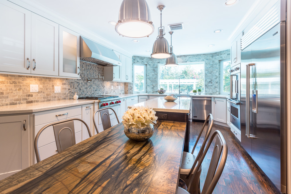 Example of a large transitional u-shaped medium tone wood floor open concept kitchen design in Miami with a farmhouse sink, shaker cabinets, white cabinets, quartz countertops, multicolored backsplash, stone tile backsplash, stainless steel appliances and an island