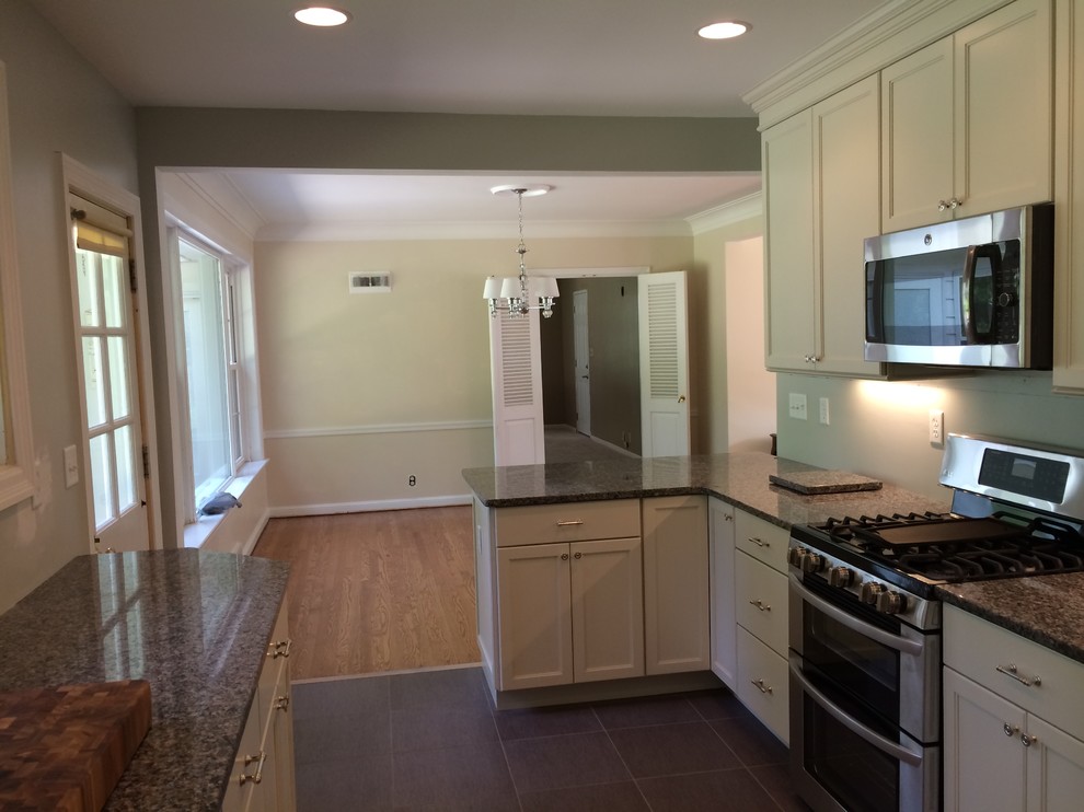 Mid-sized transitional galley kitchen photo in St Louis with a double-bowl sink, shaker cabinets, white cabinets, granite countertops, stainless steel appliances and a peninsula