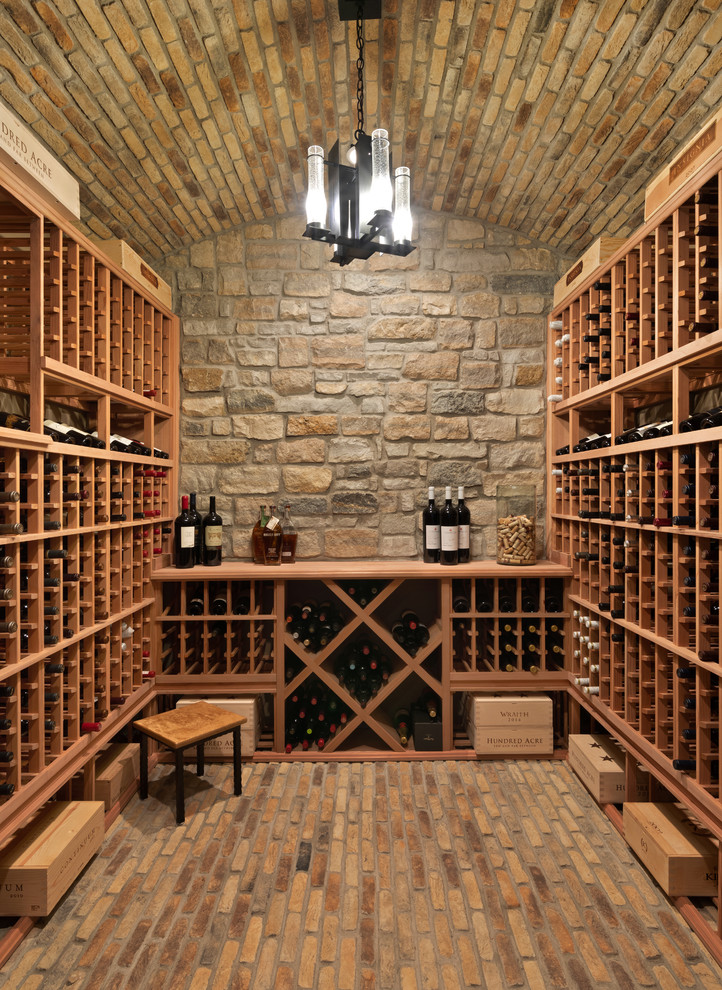 This is an example of a mid-sized traditional wine cellar in Cincinnati with brick floors and storage racks.