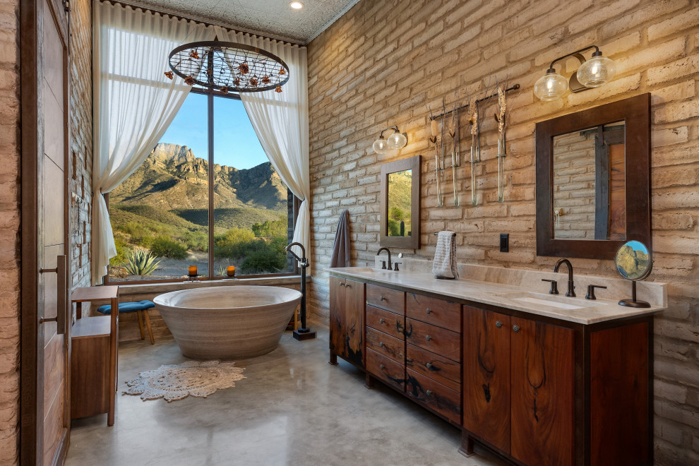 Example of a mountain style master concrete floor, beige floor and double-sink japanese bathtub design with flat-panel cabinets, medium tone wood cabinets, brown walls, quartzite countertops, white countertops and a freestanding vanity