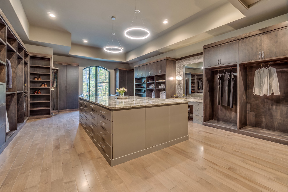 Inspiration for an expansive transitional gender-neutral walk-in wardrobe in Columbus with flat-panel cabinets, beige cabinets, light hardwood floors and beige floor.