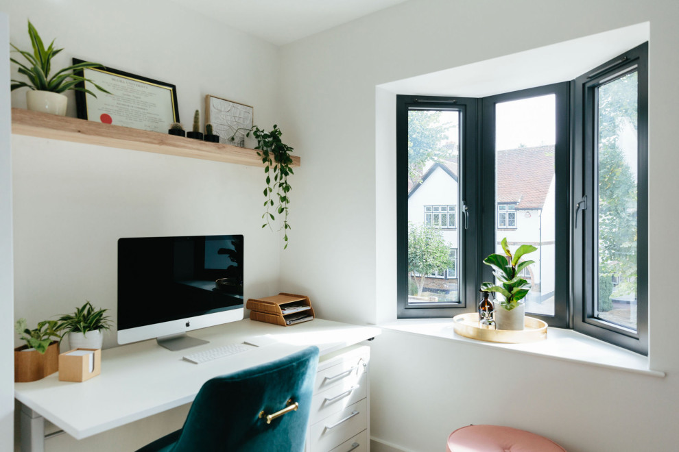 Imagen de despacho clásico renovado de tamaño medio con paredes blancas, suelo de madera en tonos medios, escritorio independiente y suelo beige