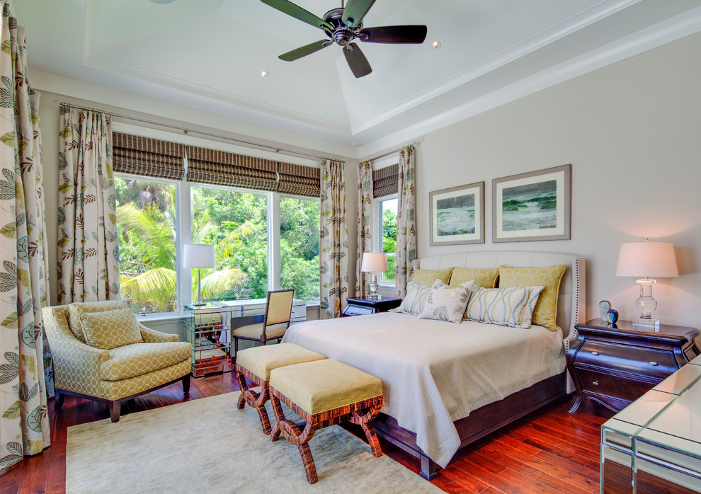 This is an example of a tropical bedroom in Tampa with grey walls and red floor.