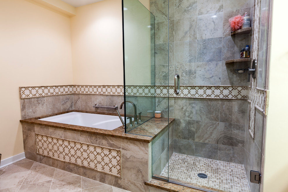 Mid-sized traditional master bathroom in Bridgeport with an undermount sink, raised-panel cabinets, medium wood cabinets, granite benchtops, an undermount tub, a shower/bathtub combo, a two-piece toilet, beige tile, porcelain tile, beige walls and porcelain floors.