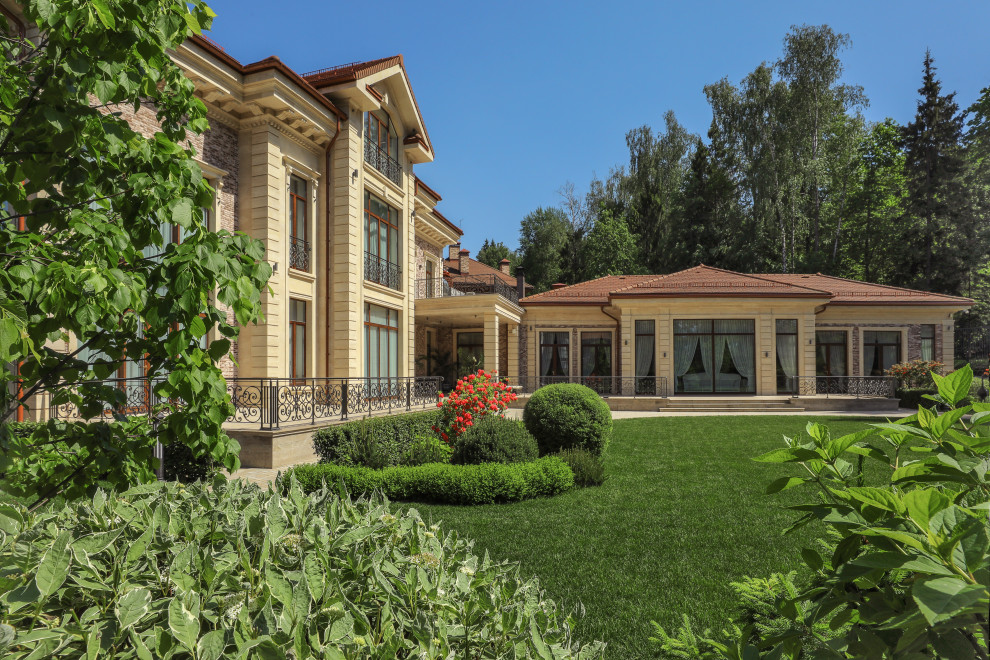 Geräumiges Klassisches Einfamilienhaus mit Steinfassade, bunter Fassadenfarbe, Mansardendach, Ziegeldach, braunem Dach und Verschalung