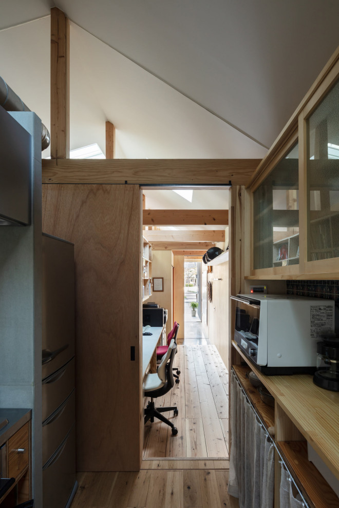 Idéer för ett litet industriellt hemmabibliotek, med bruna väggar, mellanmörkt trägolv, ett inbyggt skrivbord och brunt golv