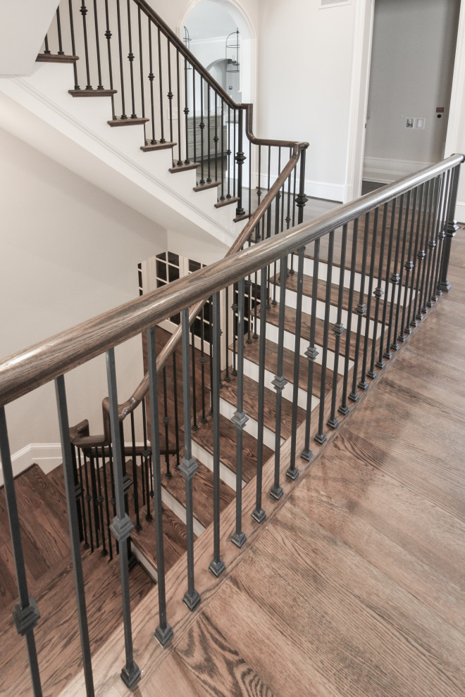 Large traditional wood floating staircase in DC Metro with painted wood risers and metal railing.