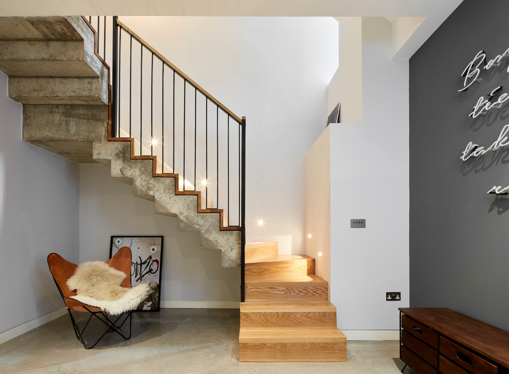 Mid-sized industrial wood u-shaped staircase in London with wood risers.