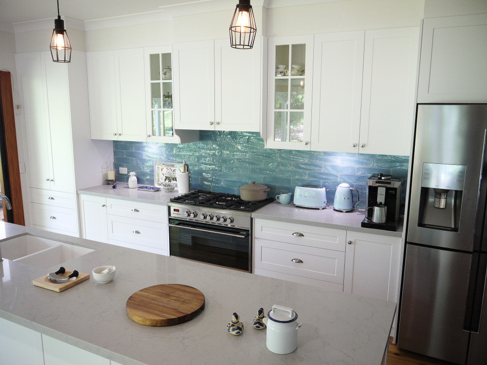 Inspiration for a large galley eat-in kitchen in Sunshine Coast with an undermount sink, recessed-panel cabinets, white cabinets, quartz benchtops, blue splashback, ceramic splashback, stainless steel appliances, light hardwood floors, with island and grey benchtop.