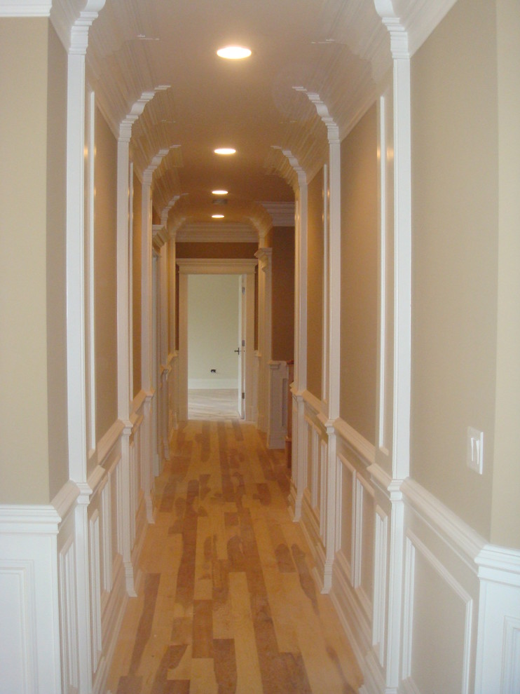 Small traditional hallway in Chicago with beige walls and light hardwood floors.