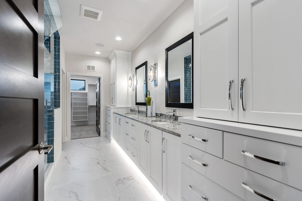 This is an example of a large transitional master bathroom in Other with shaker cabinets, a two-piece toilet, white walls, porcelain floors, an undermount sink, granite benchtops, white floor, a hinged shower door, multi-coloured benchtops, a shower seat, a double vanity, a built-in vanity and white cabinets.