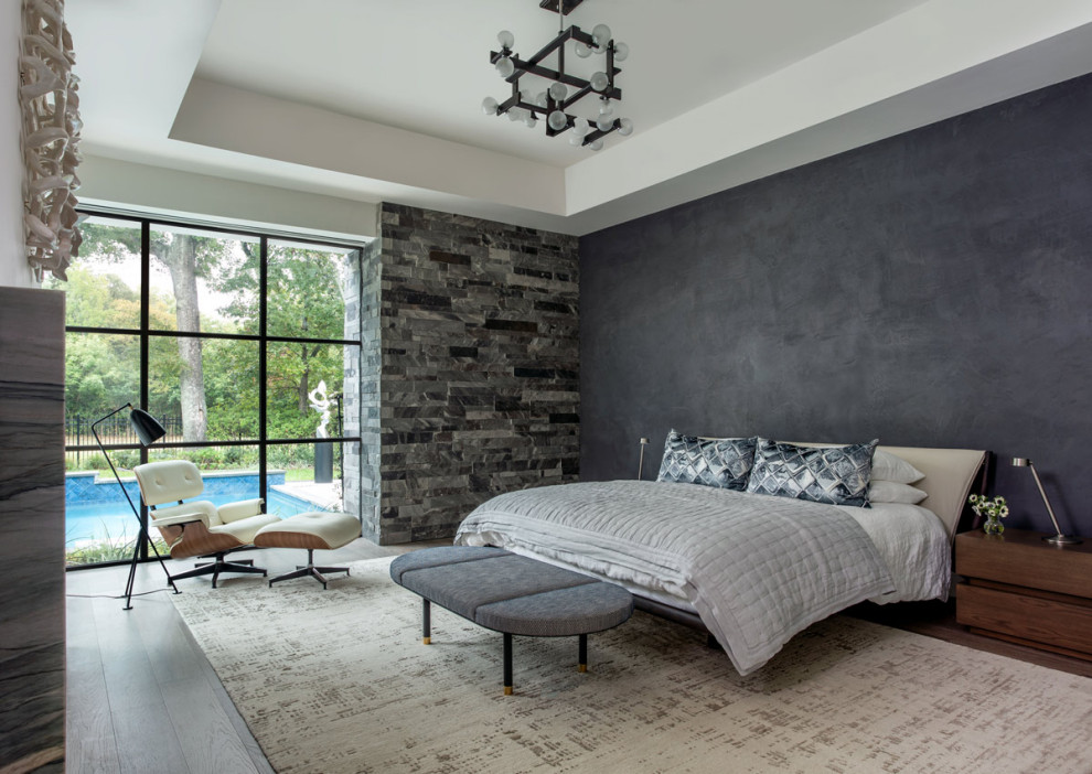 Photo of an expansive contemporary master bedroom in Houston with grey walls, dark hardwood floors, a ribbon fireplace, a stone fireplace surround and brown floor.