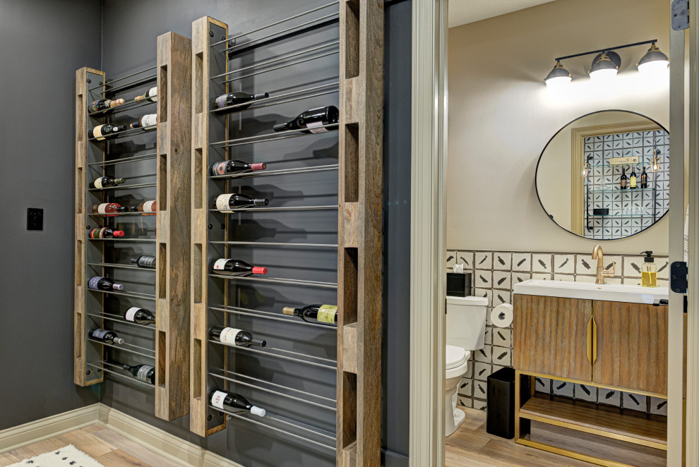 Photo of a mid-sized contemporary wine cellar in Indianapolis with light hardwood floors, storage racks and brown floor.