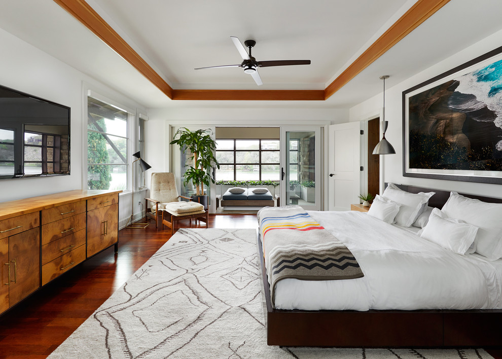 Inspiration for a mid-sized contemporary master bedroom in Austin with white walls, medium hardwood floors, no fireplace and brown floor.