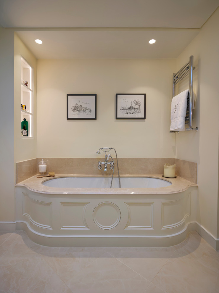 Photo of a mid-sized traditional kids bathroom in London with an alcove tub and beige tile.