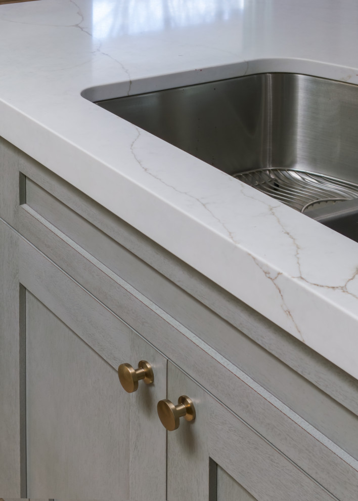 Example of a mid-sized transitional l-shaped medium tone wood floor and brown floor open concept kitchen design in Chicago with an undermount sink, shaker cabinets, medium tone wood cabinets, quartz countertops, white backsplash, ceramic backsplash, stainless steel appliances, an island and white countertops