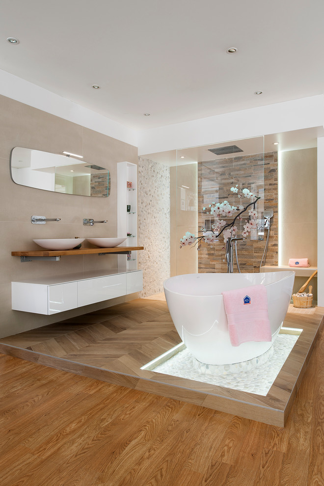 Design ideas for a contemporary master bathroom in Paris with flat-panel cabinets, white cabinets, beige walls, medium hardwood floors, a vessel sink, brown floor, a drop-in tub, a curbless shower, beige tile, wood benchtops, an open shower and brown benchtops.