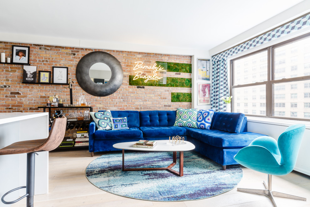 Inspiration for an eclectic living room in New York with light hardwood floors and brick walls.