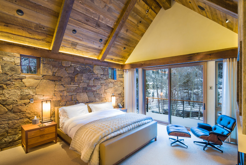 Inspiration for a large rustic guest carpeted and beige floor bedroom remodel in Denver with beige walls