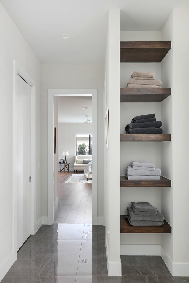 Inspiration for a mid-sized modern master bathroom in Tampa with flat-panel cabinets, dark wood cabinets, a freestanding tub, a curbless shower, a two-piece toilet, white tile, porcelain tile, white walls, porcelain floors, an undermount sink, engineered quartz benchtops, grey floor, an open shower and white benchtops.