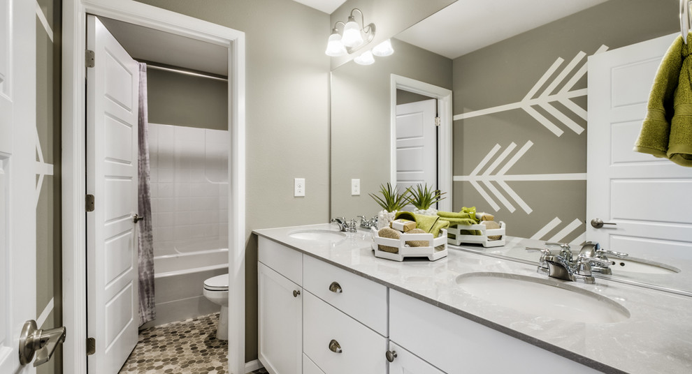 Design ideas for a mid-sized contemporary kids bathroom in Seattle with beaded inset cabinets, white cabinets, a shower/bathtub combo, a one-piece toilet, green walls, vinyl floors, an undermount sink, engineered quartz benchtops, grey floor, a shower curtain and grey benchtops.