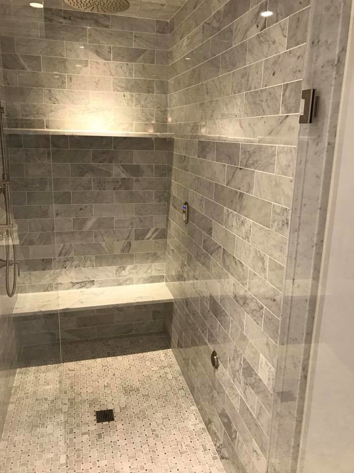 This is an example of an expansive contemporary ensuite bathroom in New York with shaker cabinets, white cabinets, a freestanding bath, an alcove shower, a two-piece toilet, grey tiles, metro tiles, grey walls, mosaic tile flooring, a submerged sink and granite worktops.