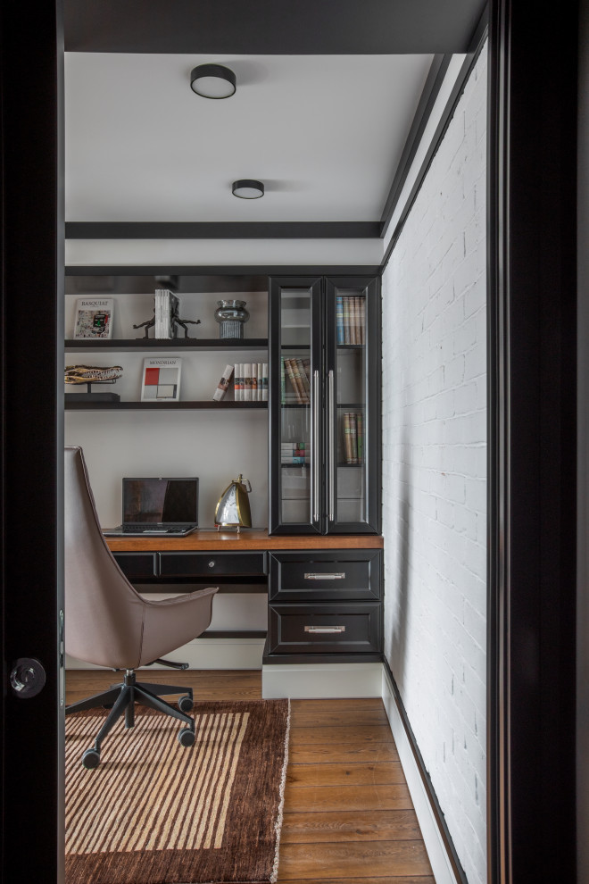 Ejemplo de despacho tradicional renovado pequeño sin chimenea con paredes blancas, suelo de mármol, escritorio empotrado, suelo marrón y panelado