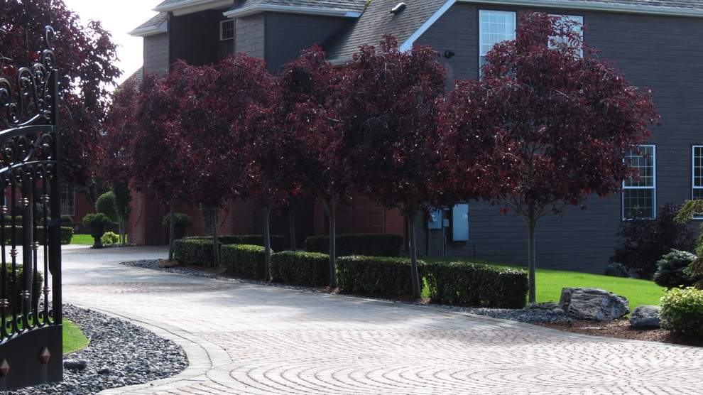 This is an example of a large rustic front yard driveway.