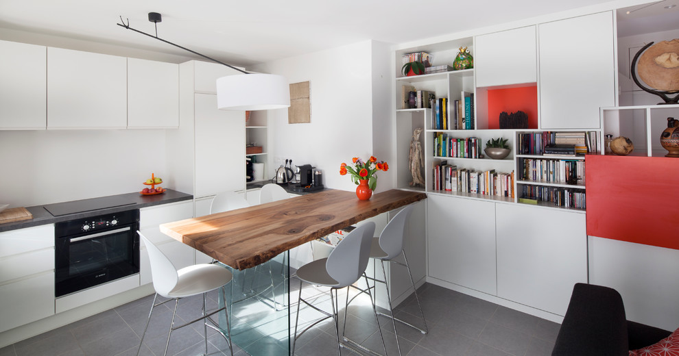 This is an example of a mid-sized contemporary open plan dining in Nantes with white walls and slate floors.