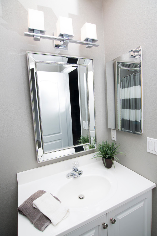 Photo of a small transitional 3/4 bathroom in San Diego with raised-panel cabinets, white cabinets, an alcove shower, grey walls, a drop-in sink and engineered quartz benchtops.