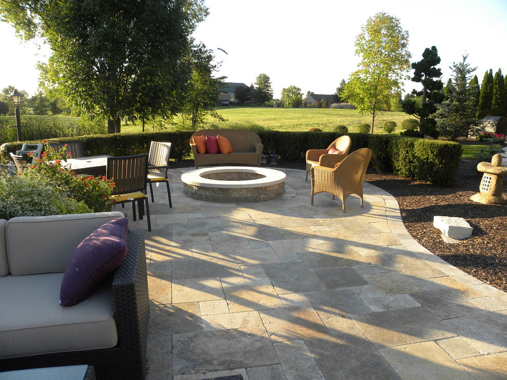 Photo of an expansive traditional backyard patio in Chicago with a water feature and natural stone pavers.