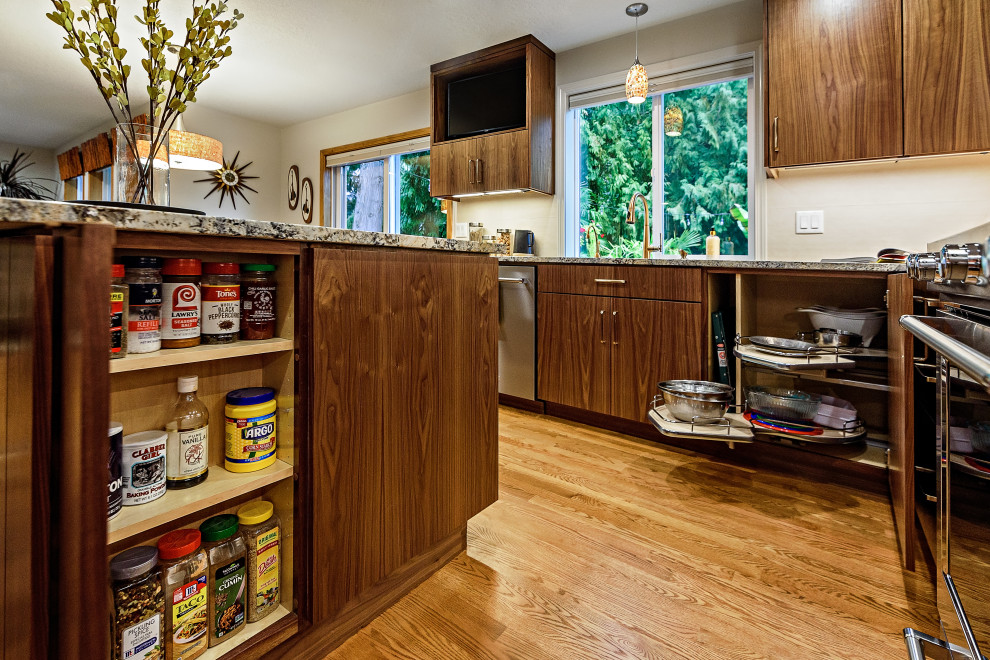 Photo of a mid-sized midcentury l-shaped kitchen in Portland with flat-panel cabinets, brown cabinets, granite benchtops, beige splashback, stainless steel appliances, medium hardwood floors, with island, brown floor and beige benchtop.