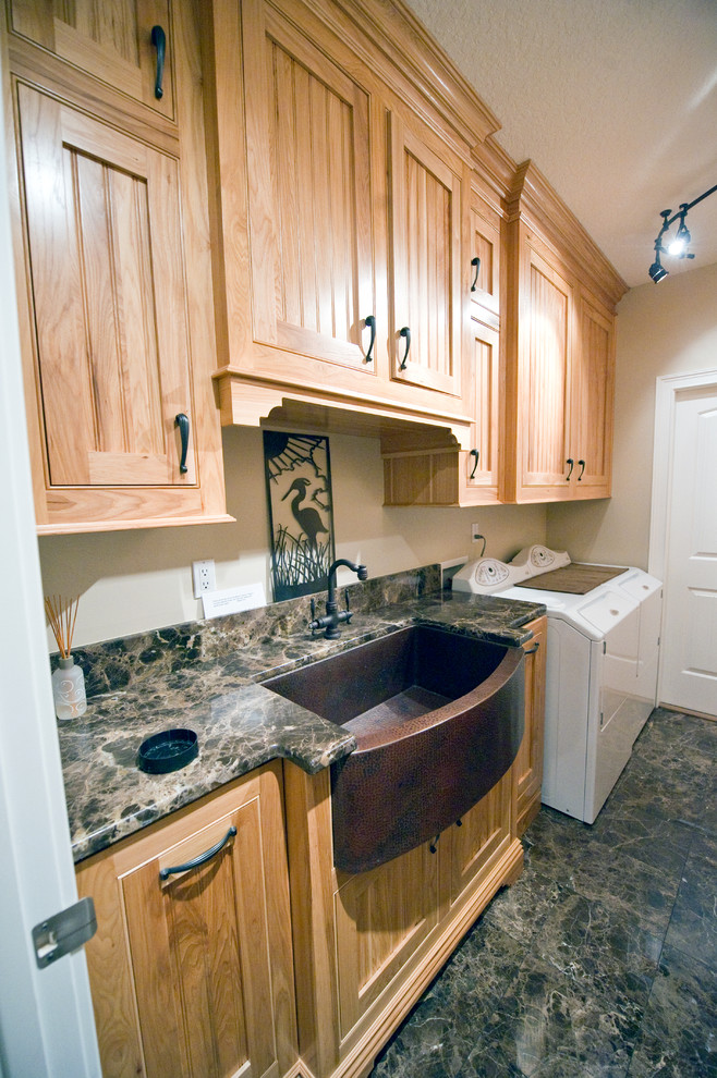 This is an example of a mid-sized arts and crafts galley dedicated laundry room in Jacksonville with a farmhouse sink, beaded inset cabinets, light wood cabinets, granite benchtops, beige walls, marble floors and a side-by-side washer and dryer.