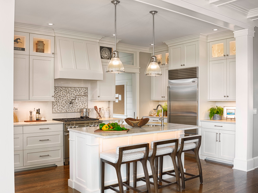 Traditional u-shaped eat-in kitchen in Boston with an undermount sink, shaker cabinets, white cabinets, white splashback, subway tile splashback, stainless steel appliances, medium hardwood floors, with island, brown floor and grey benchtop.