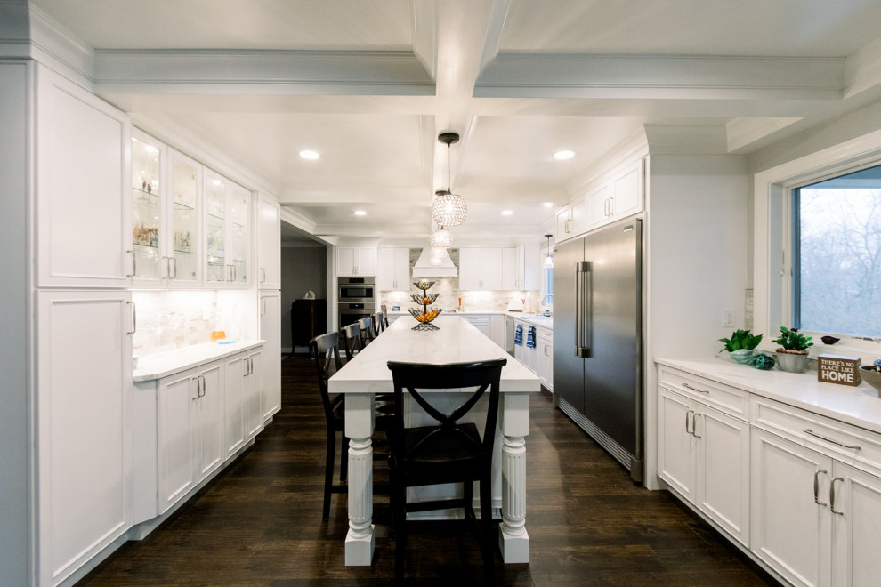 Design ideas for a large traditional kitchen in Cincinnati with white cabinets, engineered stone countertops, beige splashback, marble splashback, vinyl flooring, an island, brown floors, white worktops and a coffered ceiling.