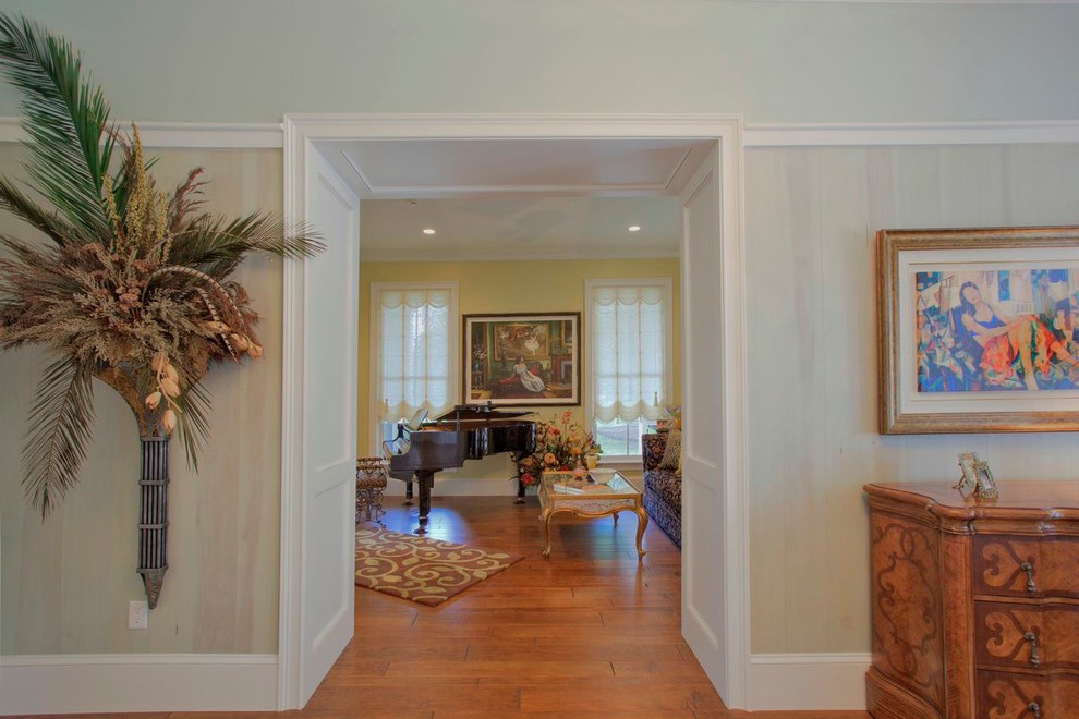 Photo of a mid-sized traditional hallway in Atlanta with beige walls, medium hardwood floors and brown floor.