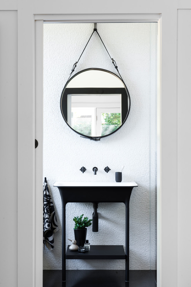 Transitional powder room in Sydney with white tile, mosaic tile, a console sink and black floor.