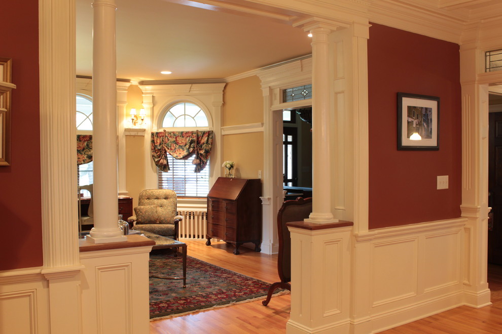 This is an example of a mid-sized traditional formal enclosed living room in New York with yellow walls, medium hardwood floors, a corner fireplace, a stone fireplace surround and no tv.