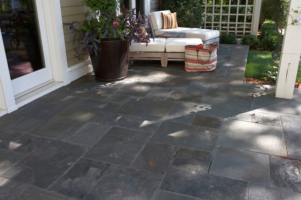 Design ideas for a large transitional backyard patio in Minneapolis with natural stone pavers and a pergola.