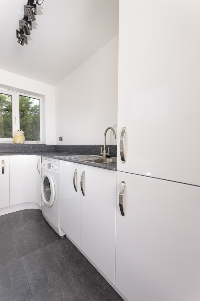 Design ideas for a small contemporary u-shaped separate kitchen in Sussex with flat-panel cabinets, white cabinets, solid surface benchtops, grey splashback, no island and grey benchtop.