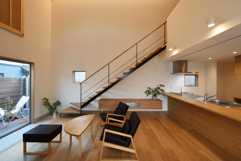 Idéer för att renovera ett stort minimalistiskt allrum med öppen planlösning, med vita väggar, mellanmörkt trägolv, en fristående TV och brunt golv