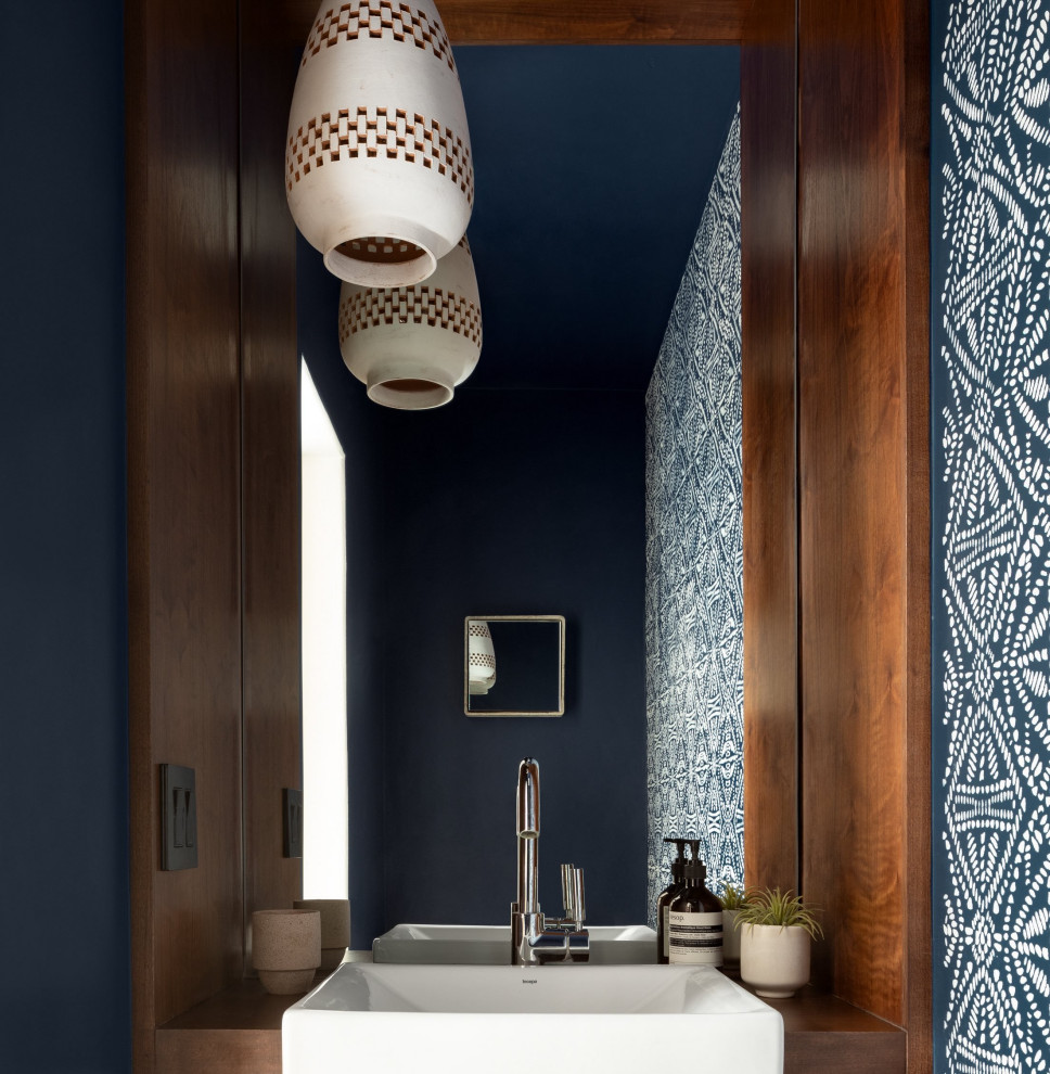 Cette image montre un WC et toilettes minimaliste de taille moyenne avec un mur multicolore, meuble-lavabo encastré, une vasque et du papier peint.