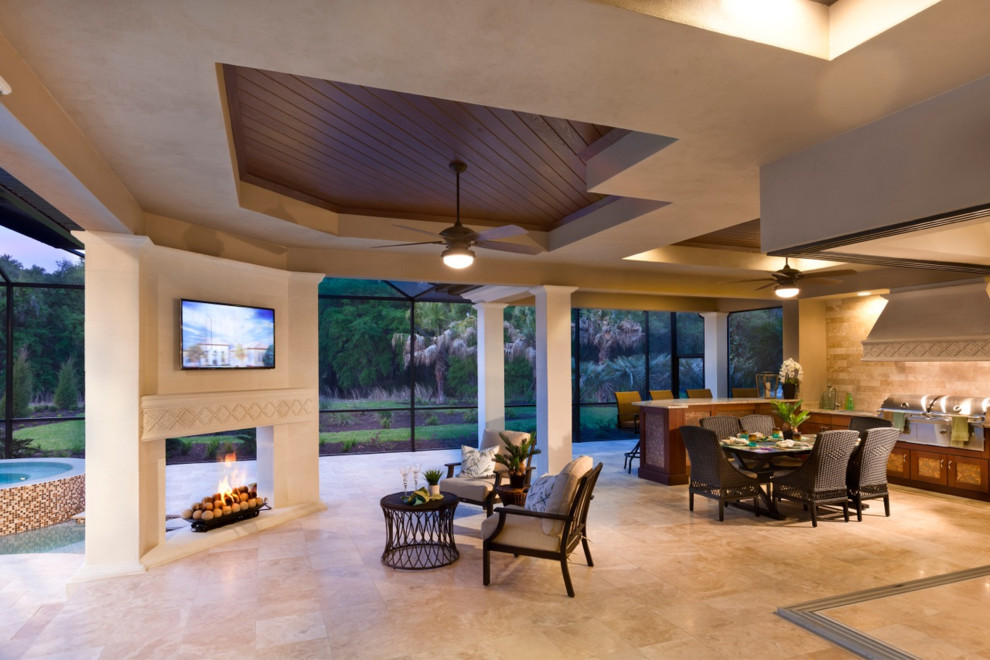 Expansive traditional backyard patio in Tampa with an outdoor kitchen, tile and a roof extension.