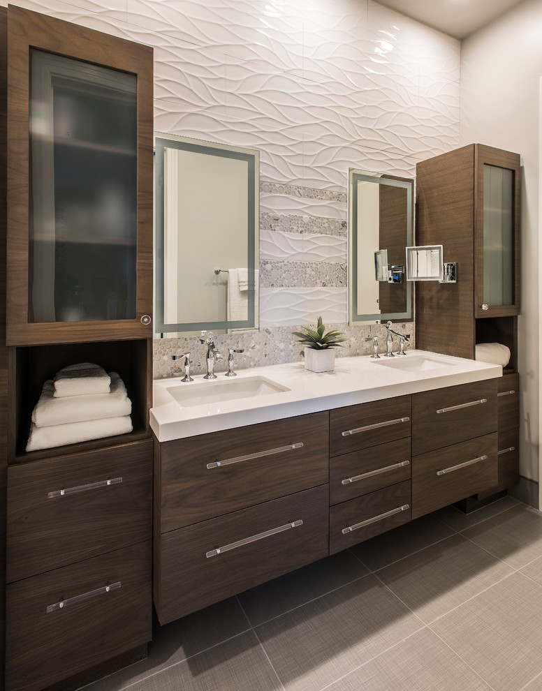 Photo of a mid-sized contemporary bathroom in Phoenix with flat-panel cabinets, an alcove shower, a one-piece toilet, white tile, porcelain tile, grey walls, porcelain floors, an undermount sink, engineered quartz benchtops, grey floor, a hinged shower door and dark wood cabinets.